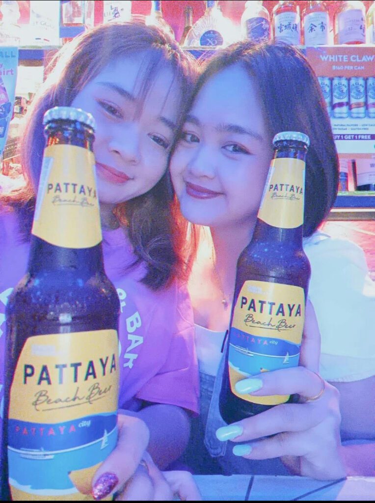 Pattaya bar girls holding beers at a nightlife bar in 2025